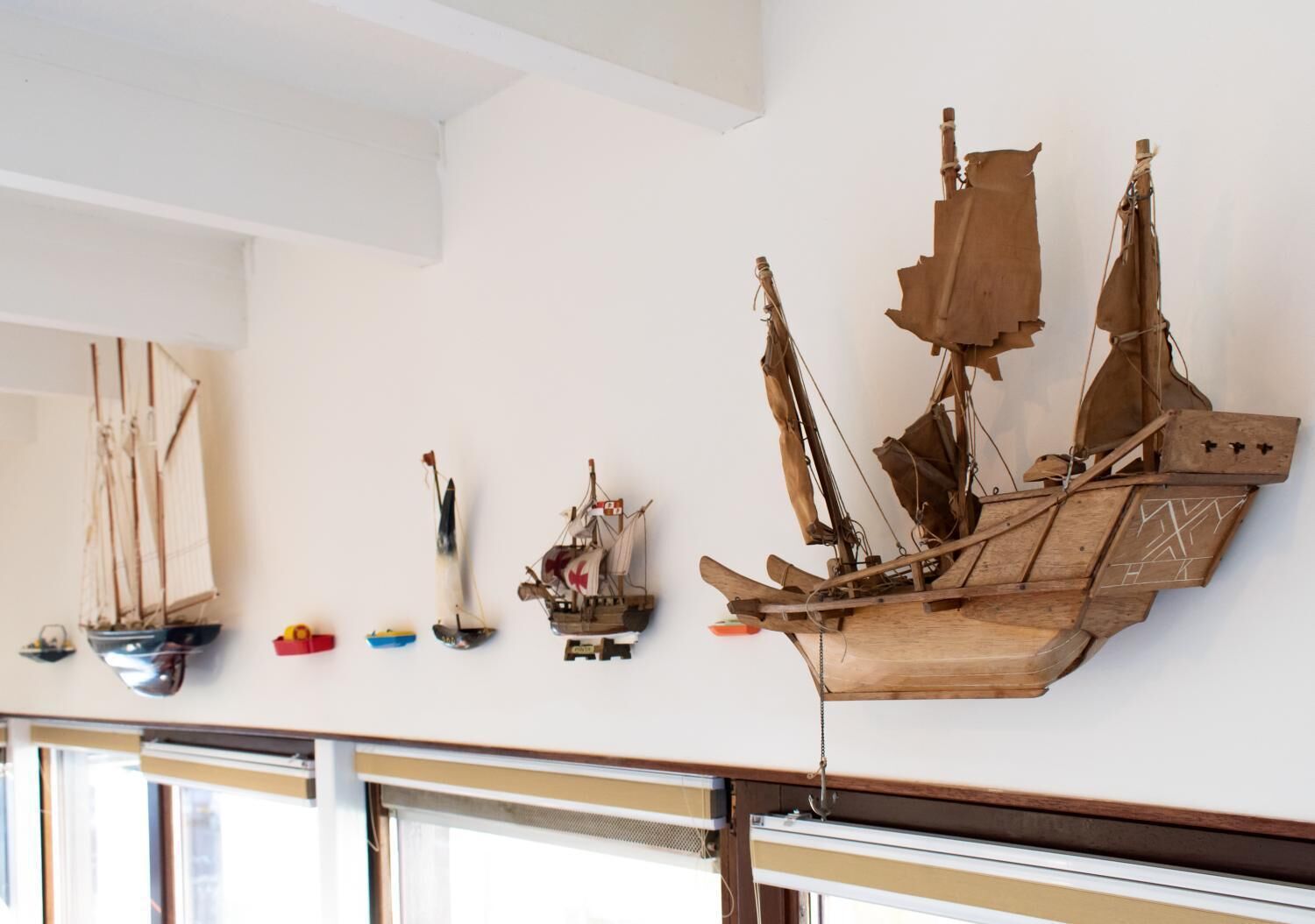 Een wandmontage met verschillende scheepsmodellen.