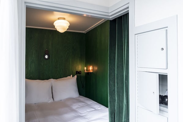 A room with a bed, green walls, a white door, and a light fixture above the bed. - SWEETS - Overtoomsesluis (Amsterdam)