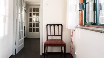 A chair in a hallway with a window and a door.