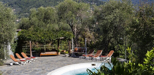 A poolside area with lounge chairs and a stone deck. - Villa San Massimo by Wonderful Italy (Rapallo)