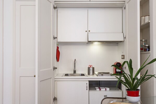 A compact kitchen with white cabinets, a stainless steel sink, and a small countertop. - Elegant Studio in the City Center by Wonderful Italy (Genoa)