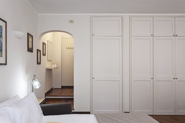 Ein Schlafzimmer mit Bett, Schreibtisch, Stuhl und Kleiderschrank.
