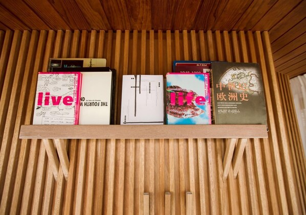 Uma prateleira de madeira com livros e um mapa.