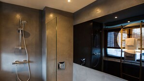A modern bathroom with a glass shower enclosure, a visible towel rack, and a window with a view of the outside. - SWEETS - Meeuwenpleinbrug (Amsterdam)