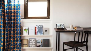 A room with a bookshelf, a desk with a laptop, and a chair. - SWEETS - Meeuwenpleinbrug (Amsterdam)
