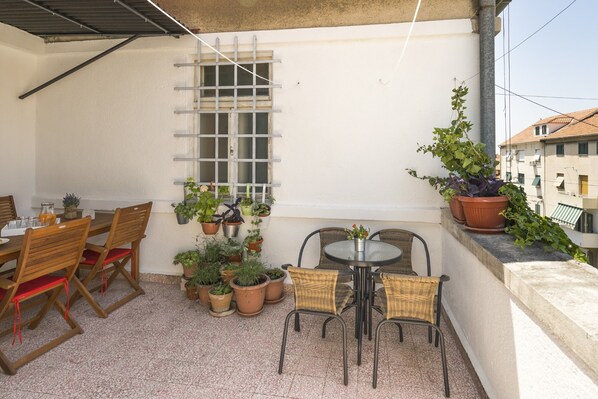 An outdoor patio with a table and chairs, surrounded by potted plants. - Apartment Dinka with terrace (Split)
