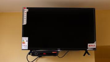 A TCL branded TV with a Netflix logo, a TCL logo, and a digital display showing 1305.