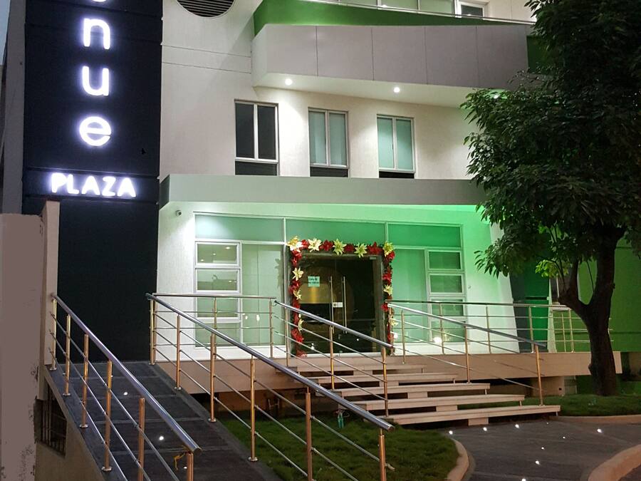 Un hotel modern amb un senyal prominent que diu "HOTEL 56 AVENUE PLAZA".