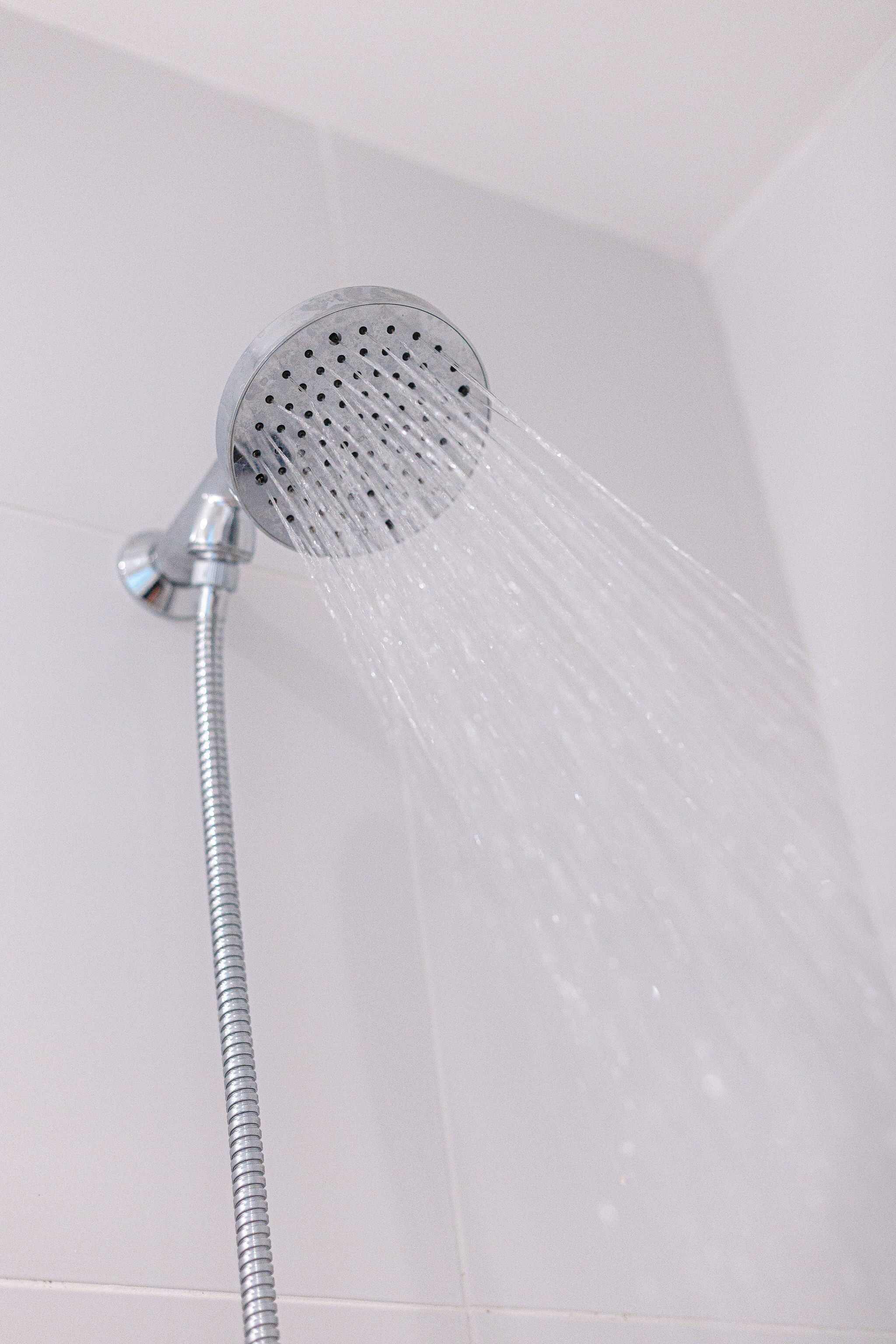 A showerhead with water flowing from it.