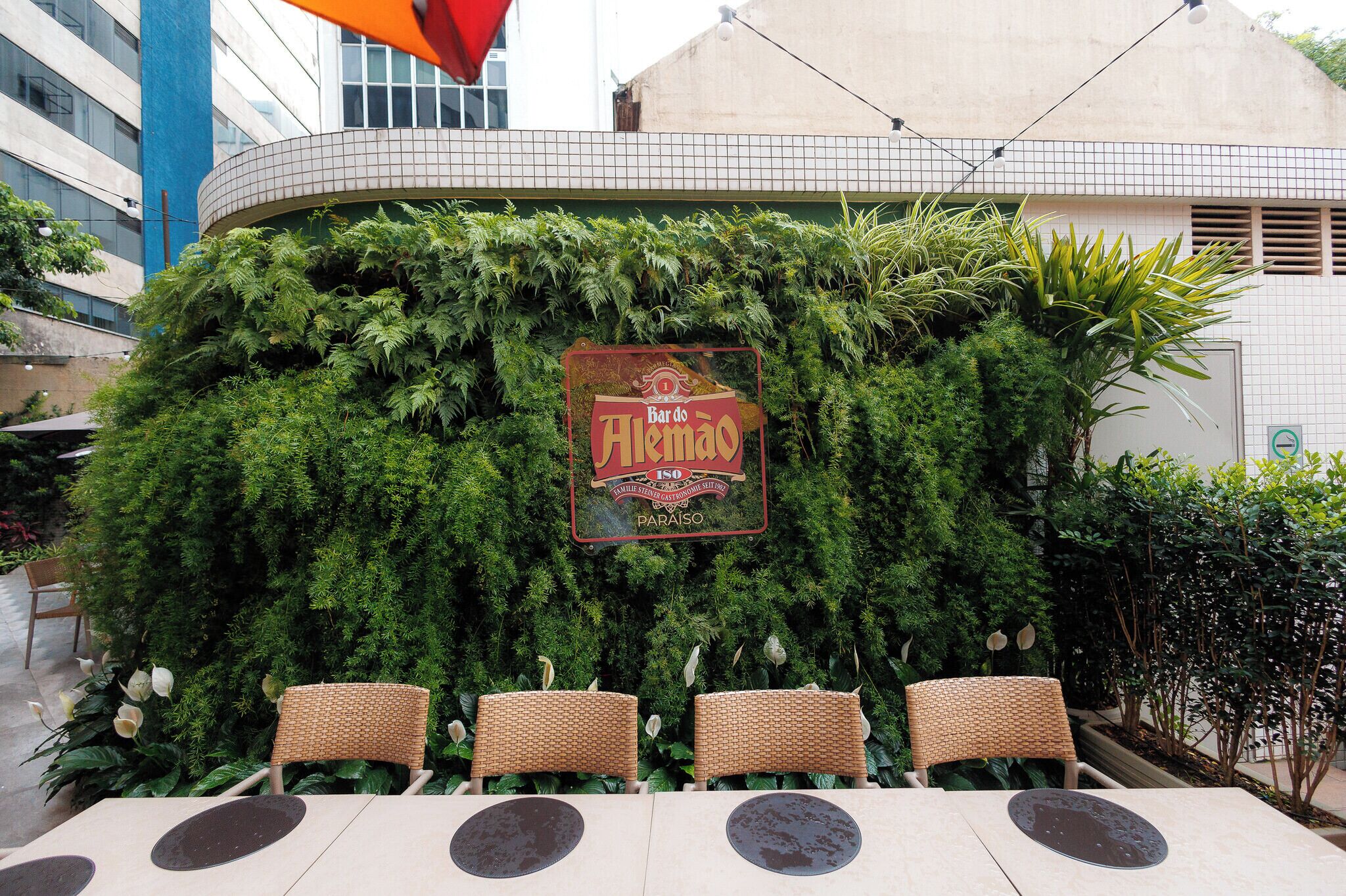 A restaurant named 'Bar de Aleman' with outdoor seating and a tiled wall backdrop.