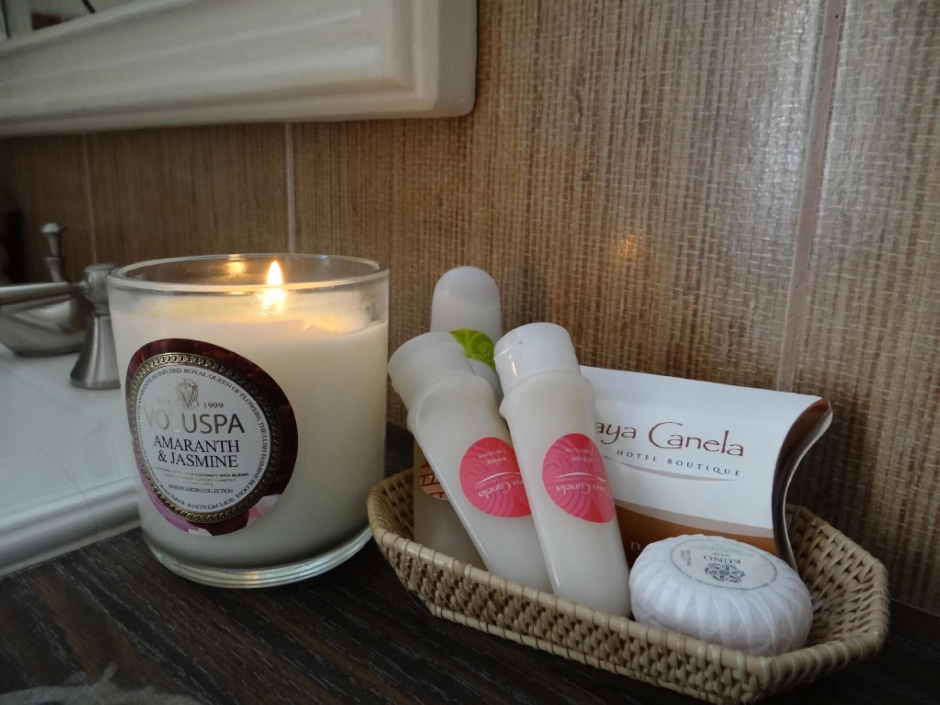 A candle, two bottles, and a box on a table.