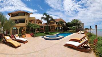 A resort with a pool, lounge chairs, and a view of the ocean.