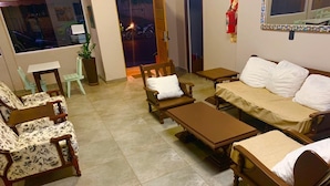 Una sala de estar con un sofá, dos sillones, una mesita de centro y una pequeña mesa.