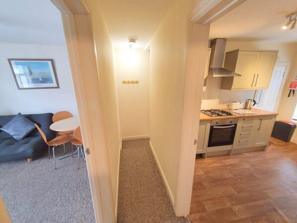 Un apartamento moderno con sala de estar, cocina y pasillo.
