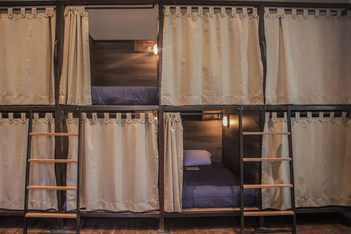 A dormitory-style room with bunk beds, each with a ladder.