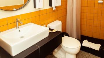 Een badkamer met een wit wastafel, toilet en douchegordijn.