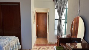A bedroom with a bed, a dresser, a mirror, and a window with curtains. - Loft del centro (Ciudad de Tlatlauquitepec)