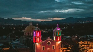 A historic building with two towers, a dome, and a courtyard. - Loft del centro (Ciudad de Tlatlauquitepec)