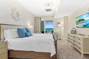 A bedroom with a bed, bedside tables, a dresser, a TV, and a view of the ocean. - BEACHFRONT l PRIVATE BEACH l BEACH SET UP INCLUDED l STUNNING WATER VIEWS (Santa Rosa Beach)