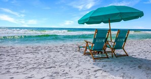 A beach with two beach chairs under a large umbrella, a sandy shore, and the ocean in the background. - BEACHFRONT l PRIVATE BEACH l BEACH SET UP INCLUDED l STUNNING WATER VIEWS (Santa Rosa Beach)