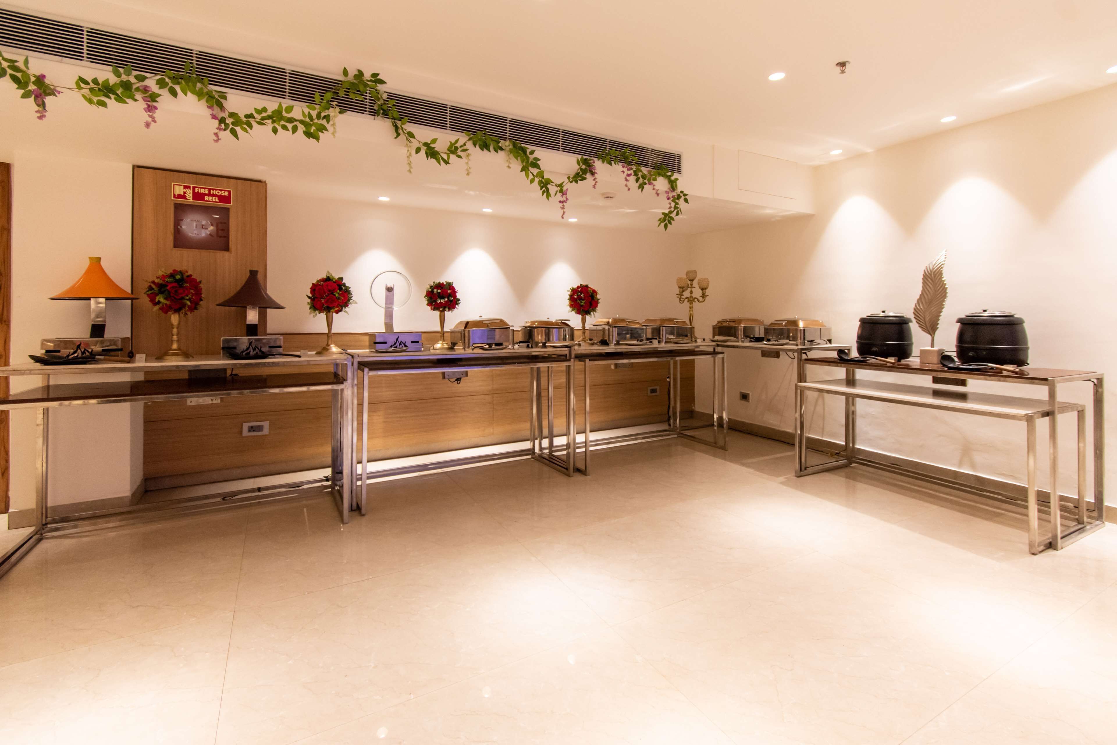 A modern kitchen with stainless steel appliances, a wooden cabinet, and decorative flowers.