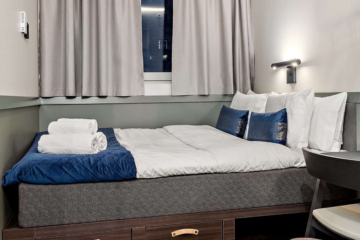 Ropa de cama hipoalergénica y caja de seguridad en la habitación