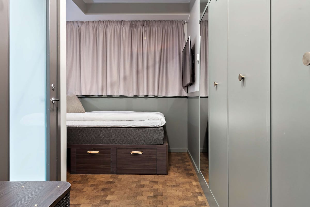 Ropa de cama hipoalergénica y caja de seguridad en la habitación