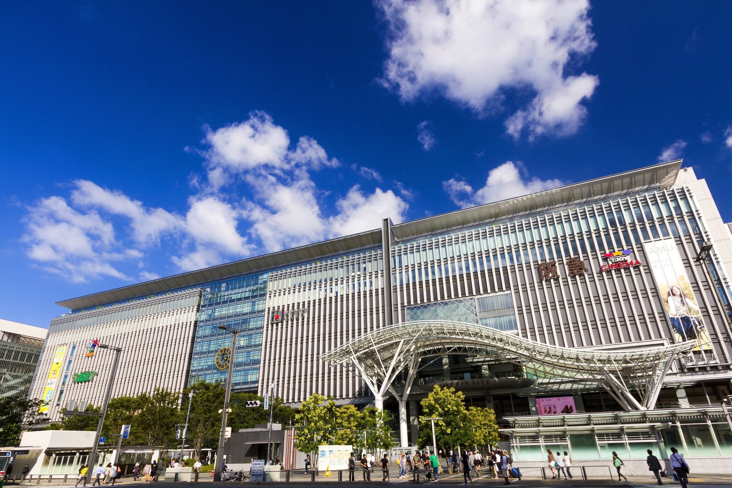 A modern building with a glass facade and a distinctive curved entrance canopy.