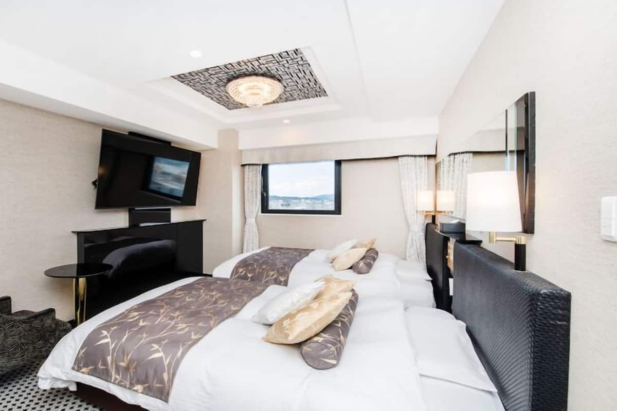 Une chambre d’hôtel avec un lit, une télévision, un bureau et une fenêtre.