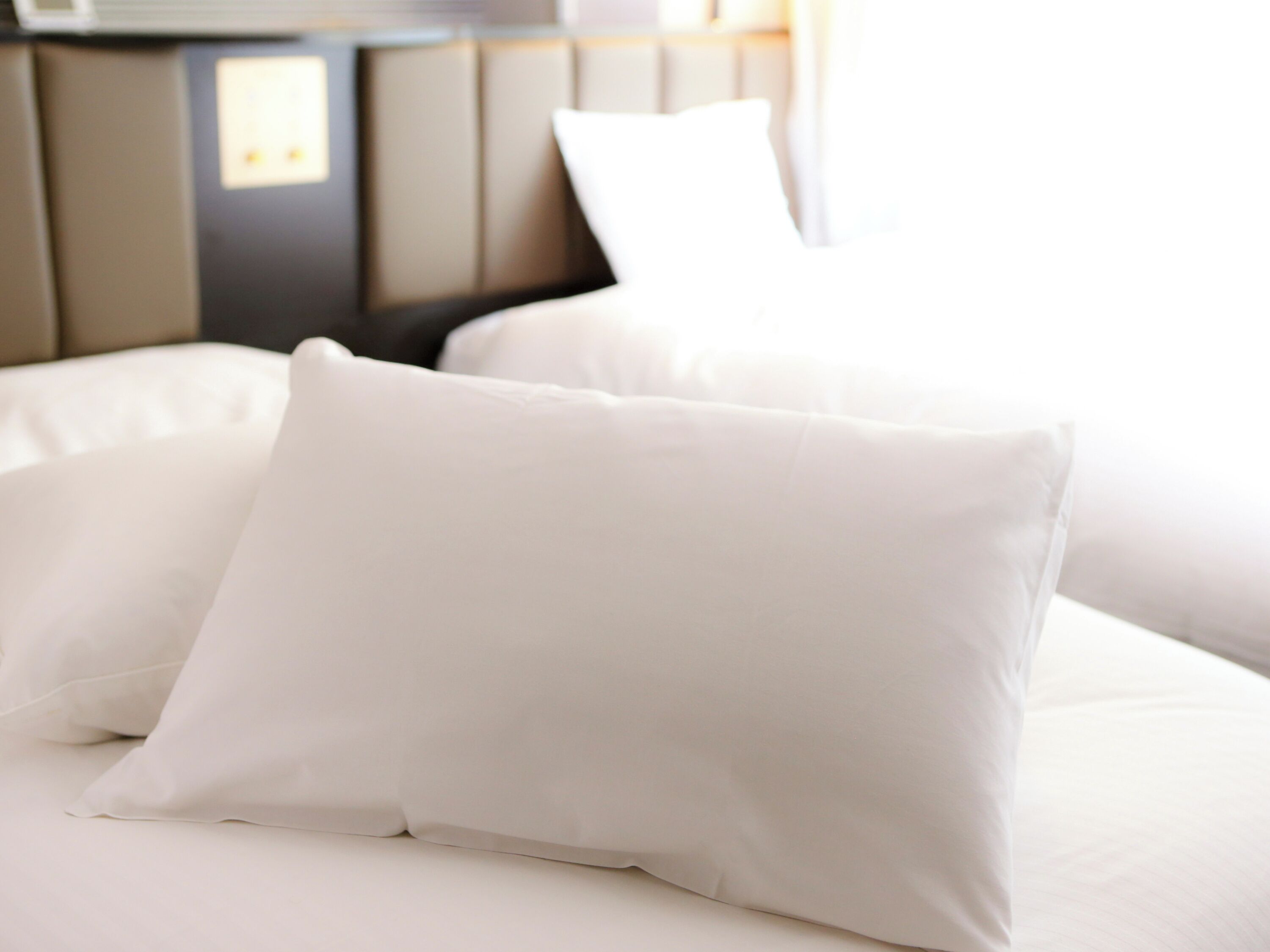A bed with white bedding and a headboard.