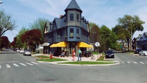 A Victorian-style building with a steeply pitched roof and a prominent tower.