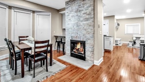 A dining area with a fireplace, wooden dining table, and chairs.