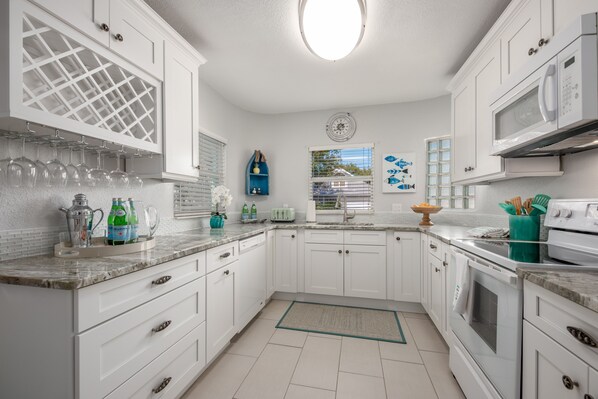 Enjoy cooking in this well-equipped kitchen with a central island, wine rack, and window with an outdoor view.