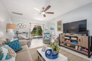 Relax in this inviting living room with a beige sofa, coffee table, and flat-screen TV.