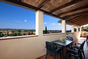 Enjoy a meal on the covered terrace with a scenic view of the surrounding mountains and trees.