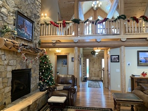 Cozy up by the fireplace in this inviting lodge, featuring a stone hearth and comfortable seating.
