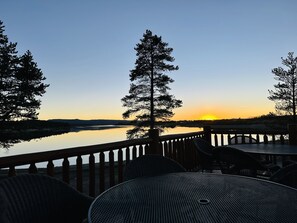 Relax on the elevated deck with a serene view of the calm body of water.