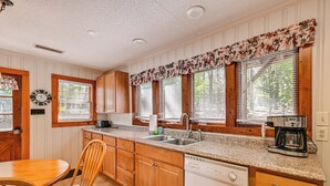 A kitchen with wooden cabinets, a granite countertop, a dishwasher, and a coffee maker. - Private Dock & Beach! Lake Norman Cottage Hideaway (Mooresville)
