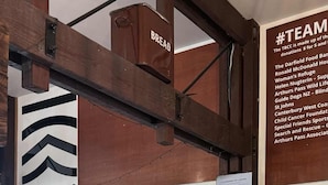 A reception area with a wooden reception desk, a sign reading "Reception", and a wall with a list of team names and logos.