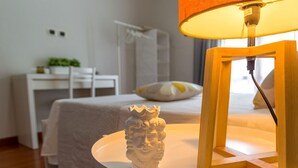 Ein ordentlich eingerichtetes Schlafzimmer mit Bett, Nachttisch und Lampe.
