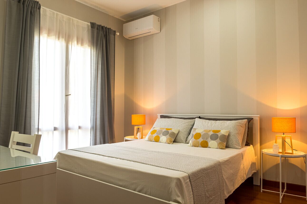 Ein Hotelzimmer mit einem Bett, zwei Nachttischlampen, einem Schreibtisch und einem Sessel.