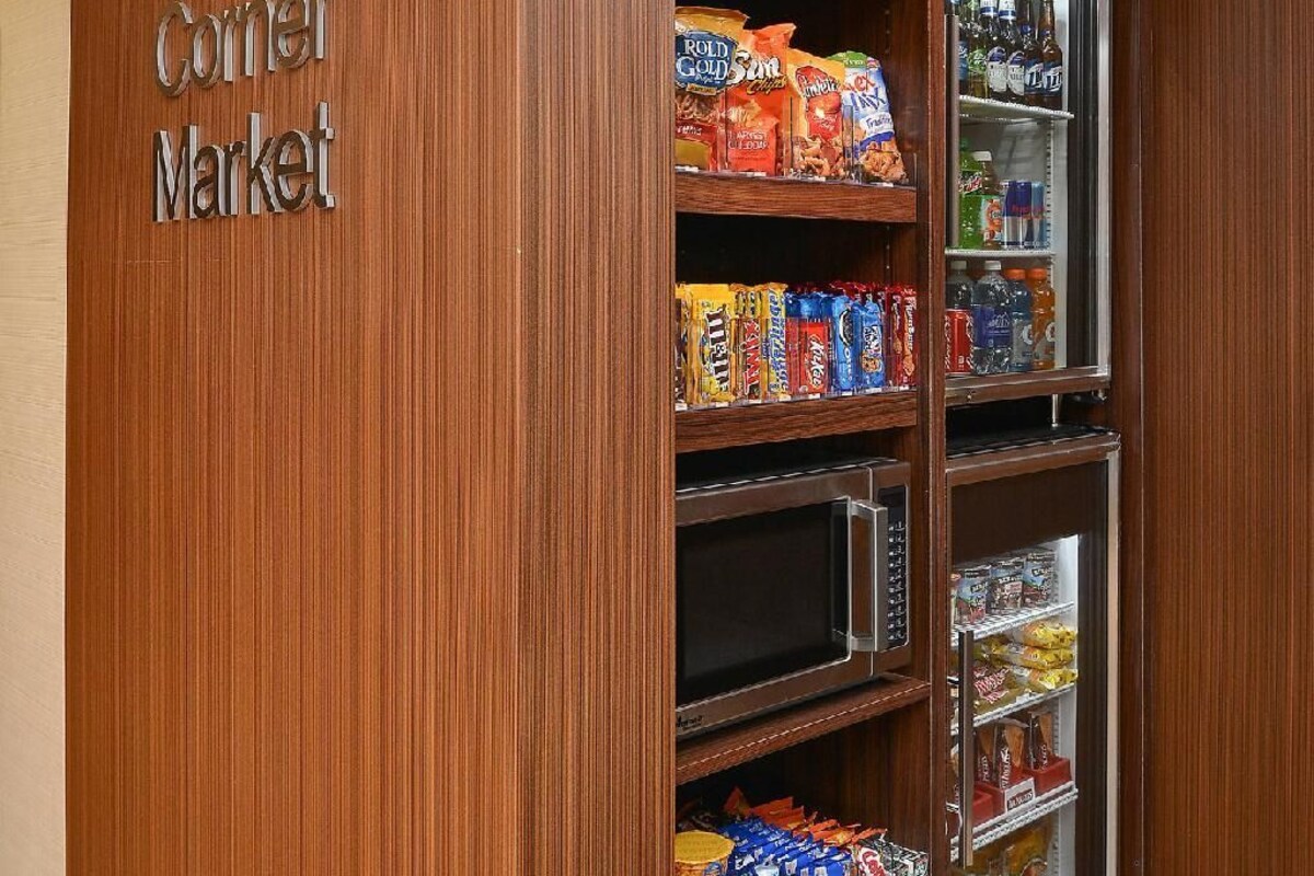 A corner market with shelves stocked with snacks and beverages.