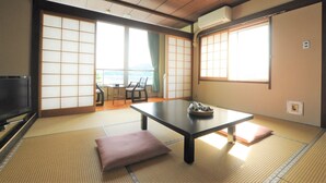 Una habitación japonesa tradicional con suelo de tatami, una mesa baja y puertas correderas.