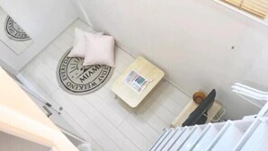 Een hotelkamer met een bed, een tafeltje en een kussen.