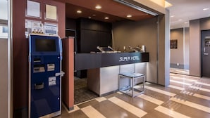A reception area with a blue self-service kiosk, a reception desk labeled "Super Hotel," and a check-in counter. - Super Hotel Matsumoto Ekimae (Matsumoto)