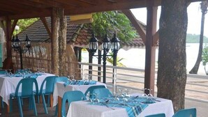 A restaurant with tables set for dining, outdoor seating, and a view of the water. - Eden Kay - 100m from the beach (Les Trois-Îlets)