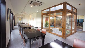 A conference room with a long table, chairs, and a glass partition. - Hotel Gen Kikukawa (Kikugawa)
