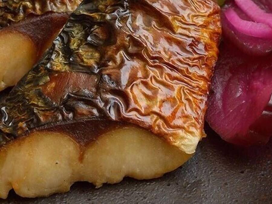En fisk med krispig hud, serverad med inlagda grönsaker.
