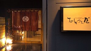A traditional Japanese entrance with a wooden gate, a hanging sign with Japanese characters, and a potted plant beside the gate. - Hotel Gen Kikukawa (Kikugawa)