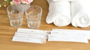 Een houten tafel met twee glazen, een witte handdoek en diverse verpakkingen tandenborstels.